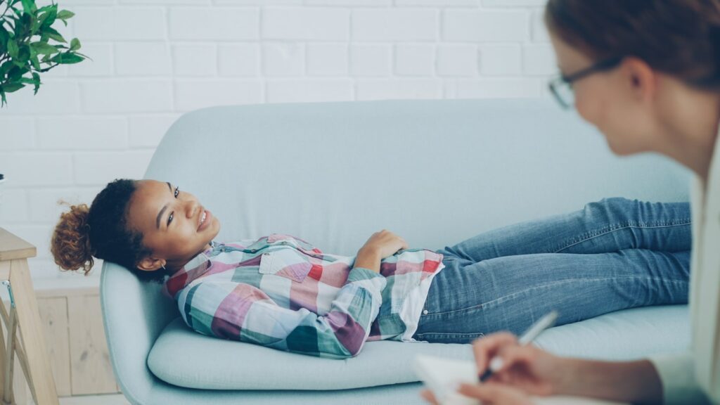 Persona recostada en un sillón durante un proceso de terapia psicológica para relajación, manejo emocional y bienestar mental